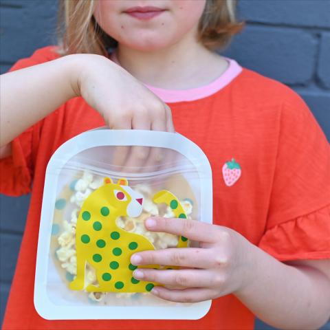 A child holds a snack bag with a Leopard design