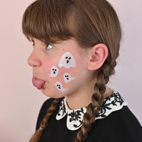A girl has ghosts painted on her face