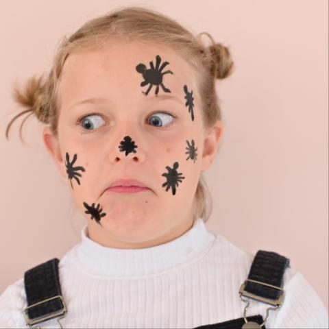 A girl has spiders painted on her face