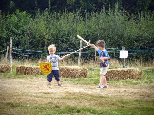 boys playing with medieval wooden swords