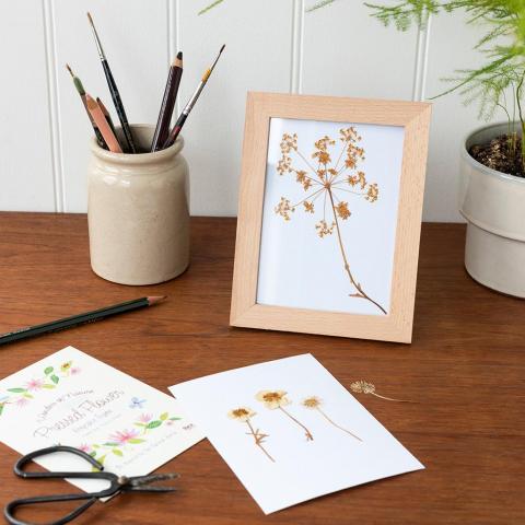 Wooden frame on a desk, with some pressed flowers inside