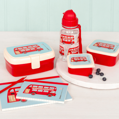 A lunchbox, water bottle and notebooks with a red bus design